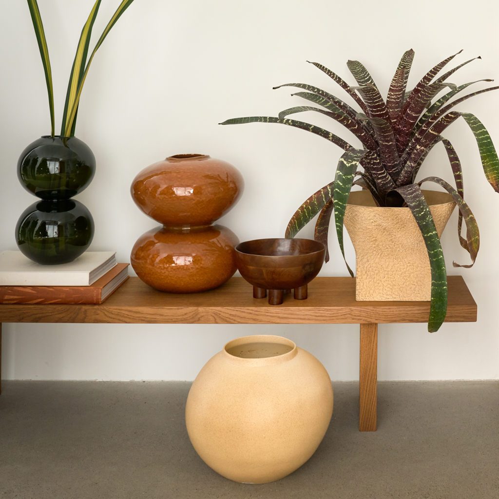 A round, organic shaped wooden bowl with four small feet, finished in a warm sophisticated dark brown finish. Made of eco-friendly mangowood, of which the timber is harvested after the mango tree passed its fruit-bearing life span.