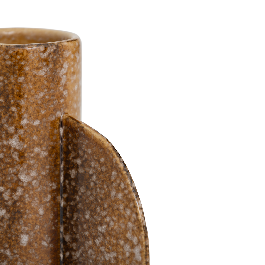 A small bodied vase featuring two organically shaped half-circle ears on the sides, finished in a lively brown shiny reactive glaze with outspoken tonal variation. Made from a balanced mix of recycled and virgin ceramics. One-flower vase.