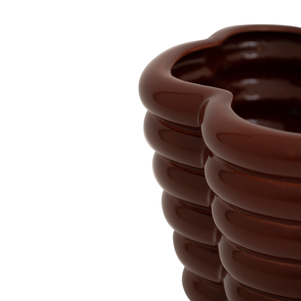 A sculpted, layered and bulky ceramic vase in the deep and rich shiny solid colour brandy, creating a bold and grounded presence. Statement piece