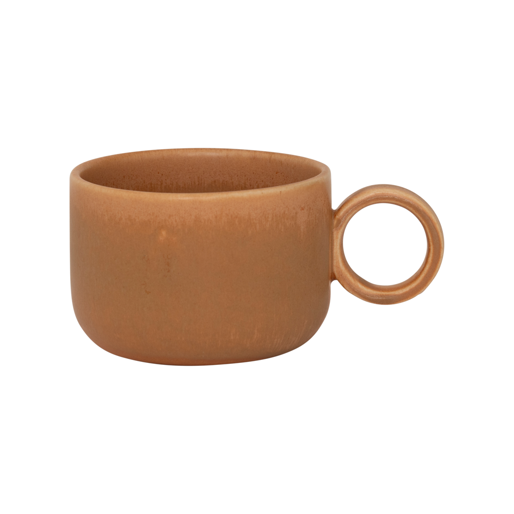A ceramic mug in mid-brown in a reactive glaze with a large rounded handle, giving it a sculptural, contemporary look. Made from a balanced mix of recycled and virgin ceramics.