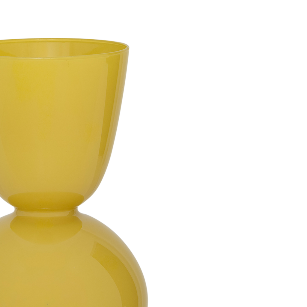A recycled glass vase with a rounded form and a subtly flared opening, its silhouette flowing inward at the centre to create a balanced, feminine shape. In the vibrant opaque coloured yellow yasmine.
