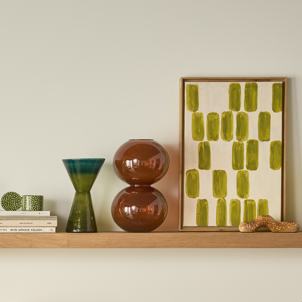 Recycled glass, transparant coloured vase in a statement hourglass shape, with clean, straight lines that meet at the centre. A gradient of two colours of green- banana palm for the body and green heron on the top