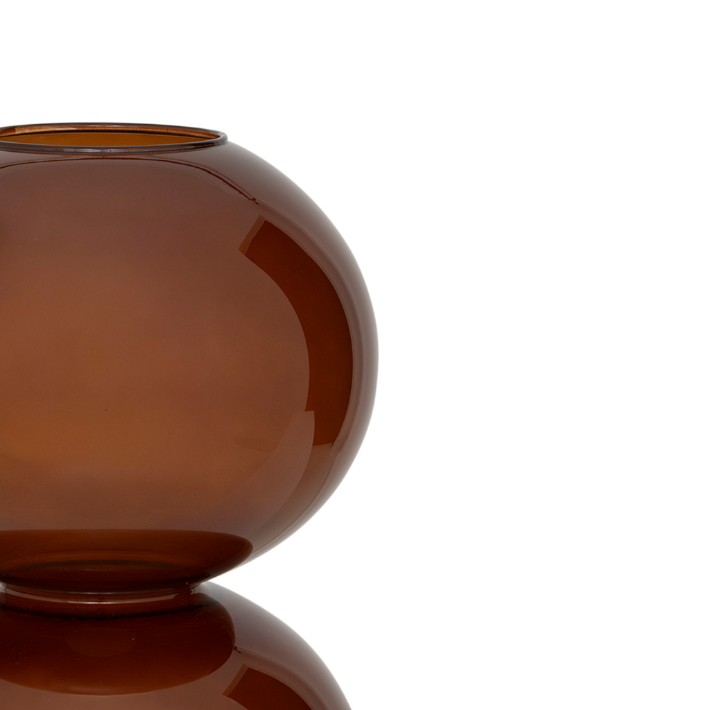 A large recycled glass vase with two layered spherical forms, balanced in the inviting and warm sugar almond colour. Transparant coloured.