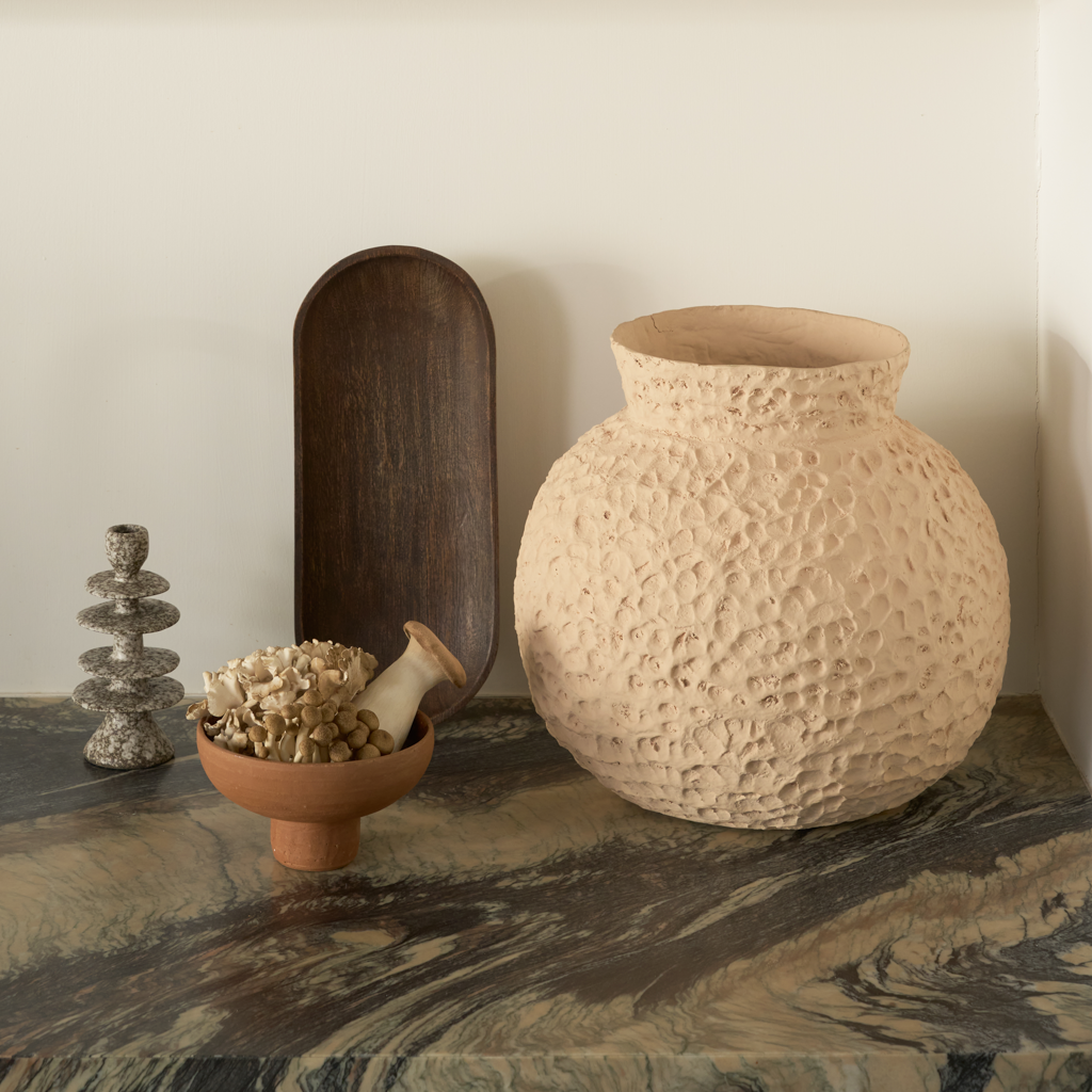 A candleholder in an expressive reactive glaze in a downtown brown colour, composed of layered irregular discs Crafted from a balanced mix of recycled and virgin ceramics.
