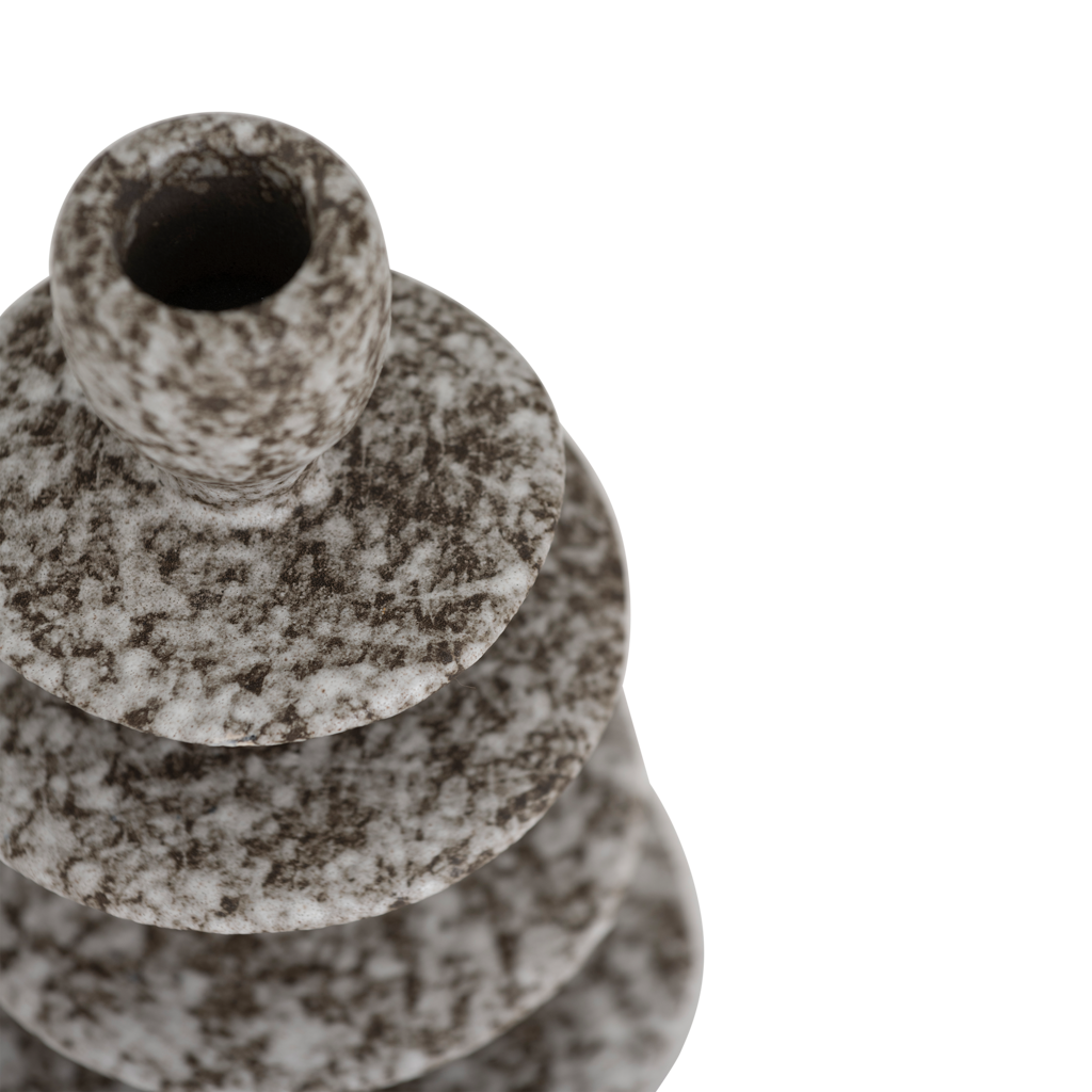A candleholder in an expressive reactive glaze in a downtown brown colour, composed of layered irregular discs Crafted from a balanced mix of recycled and virgin ceramics.