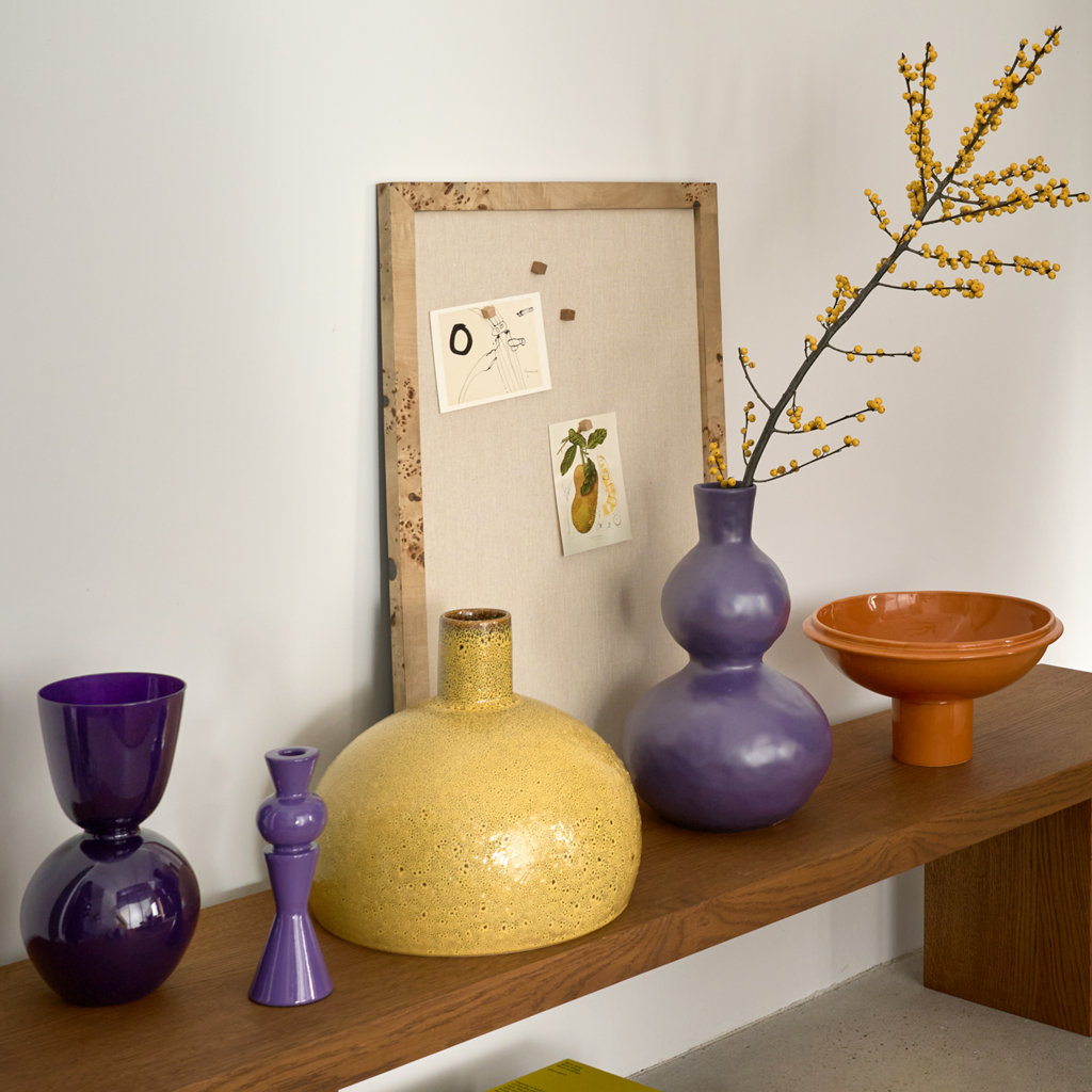 A candleholder composed of a mix of geometric shapes that come together in an engaging design, crafted from a balanced mix of recycled and virgin ceramics. In crown jewel, an opulent and powerful colour.