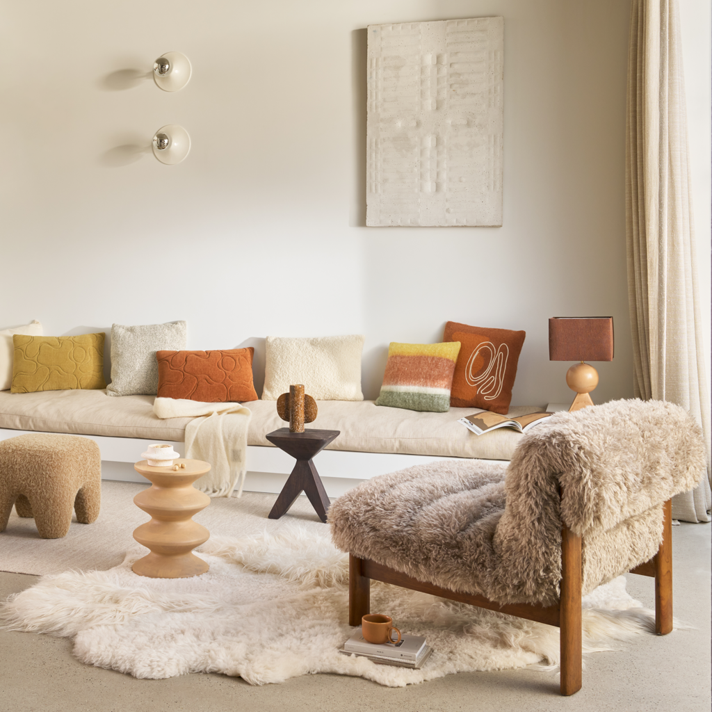 A brushed wool blend cushion in the warm and inviting colour sugar almond with an deep orange a-symmetric organic artwork. Finished by an organic cotton line embroidery in off-white.