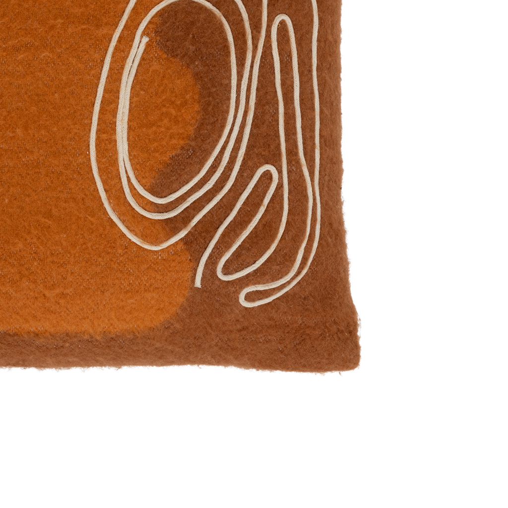 A brushed wool blend cushion in the warm and inviting colour sugar almond with an deep orange a-symmetric organic artwork. Finished by an organic cotton line embroidery in off-white.