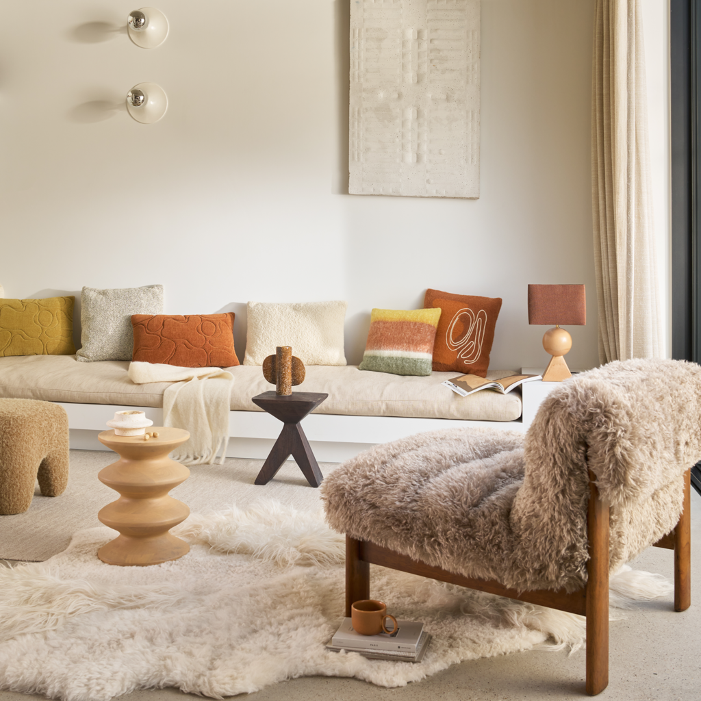 A brushed wool blend decorative cushion featuring bold vertical stripes in a contrast mix of warm, earthy tones.