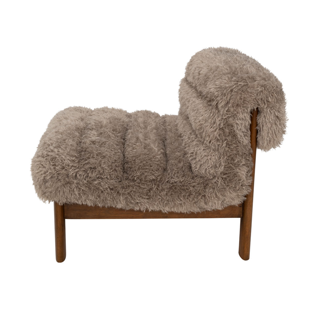 A lounge chair with visible rubber wood legs and a quilted and padded cushioned seat in a draped design. Made from a fluffy poodle fabric in the versatile colour taupe.
