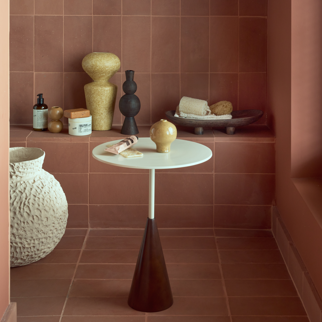 A sleek, modern side table featuring a warm, cappuccino-toned solid wood base and a soft, matt off-white metal top. Made of eco-friendly mangowood, of which the timber is harvested after the mango tree passed its fruit-bearing life span.