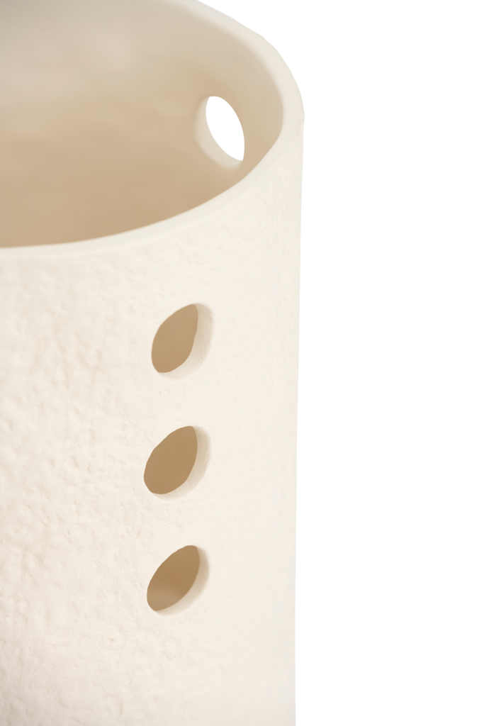 A textured and tactile ceramic table lamp in an handcrafted shape, in the soft colour almond milk. Its design brings expression but also calm, grounded presence.