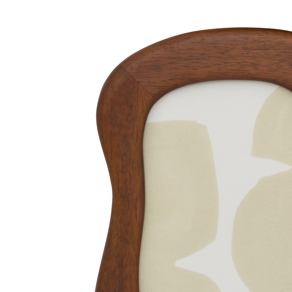 A photo frame with stand in an organic, flowing design finished in a warm golden oak colour. Made of eco-friendly mangowood, of which the timber is harvested after the mango tree passed its fruit-bearing life span.