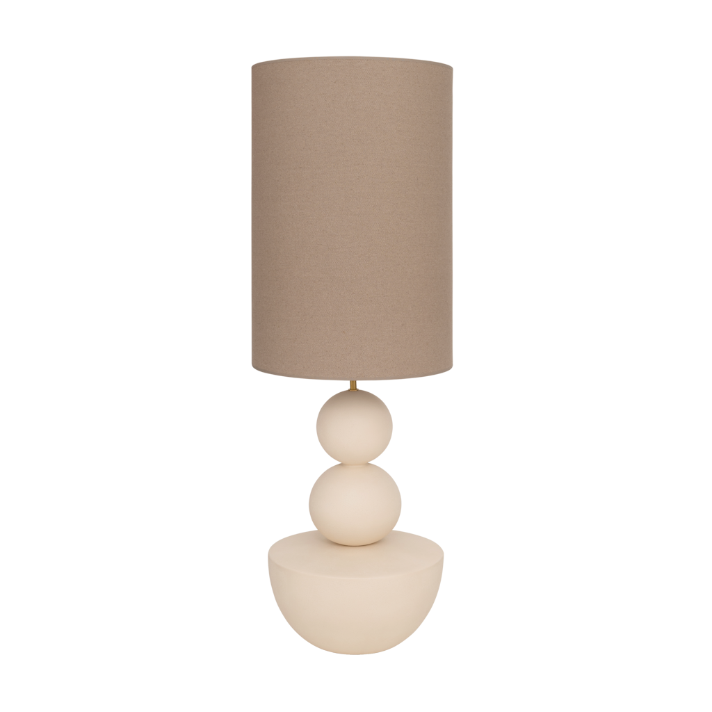 A very generous handmade minimalistic, sculptural table lamp in almond milk with an organic, stacked design and a sand coloured linen shade.