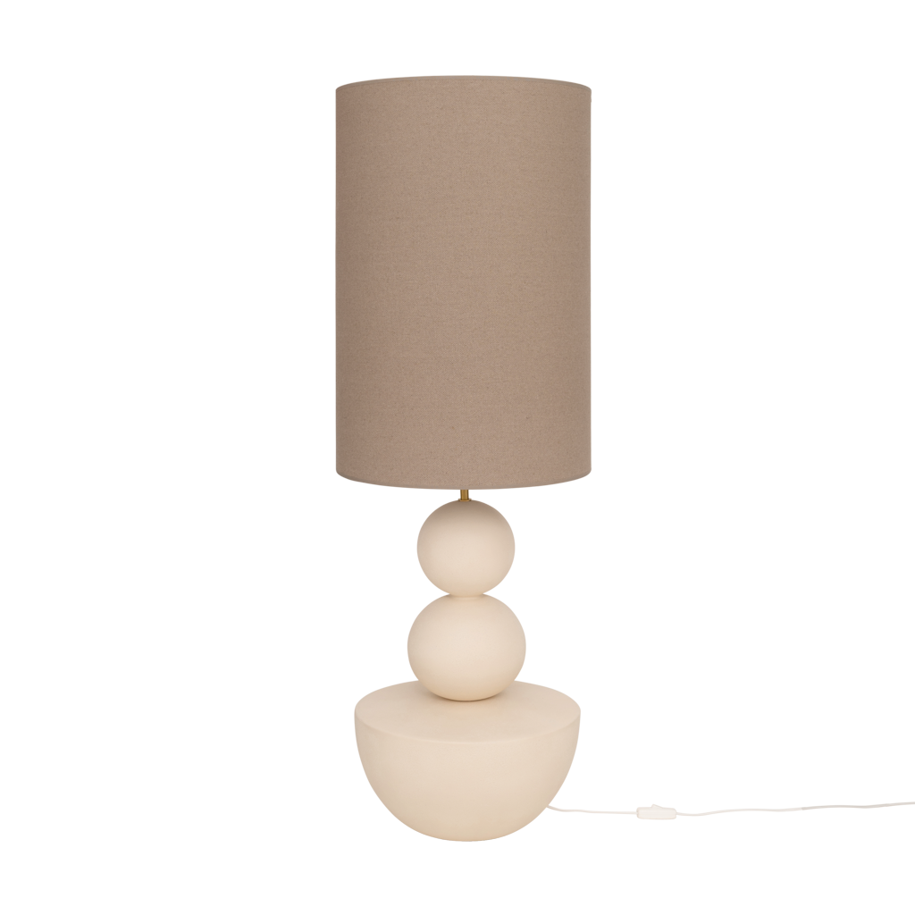 A very generous handmade minimalistic, sculptural table lamp in almond milk with an organic, stacked design and a sand coloured linen shade.