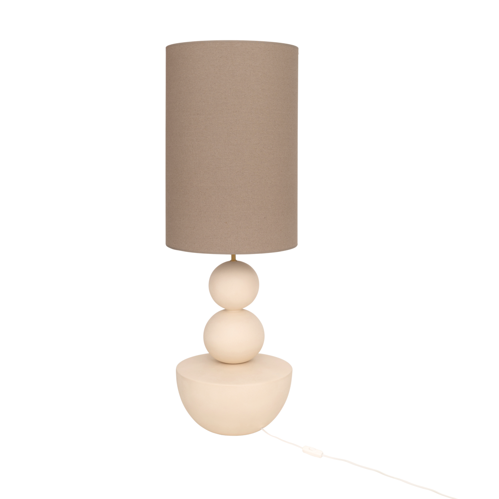 A very generous handmade minimalistic, sculptural table lamp in almond milk with an organic, stacked design and a sand coloured linen shade.