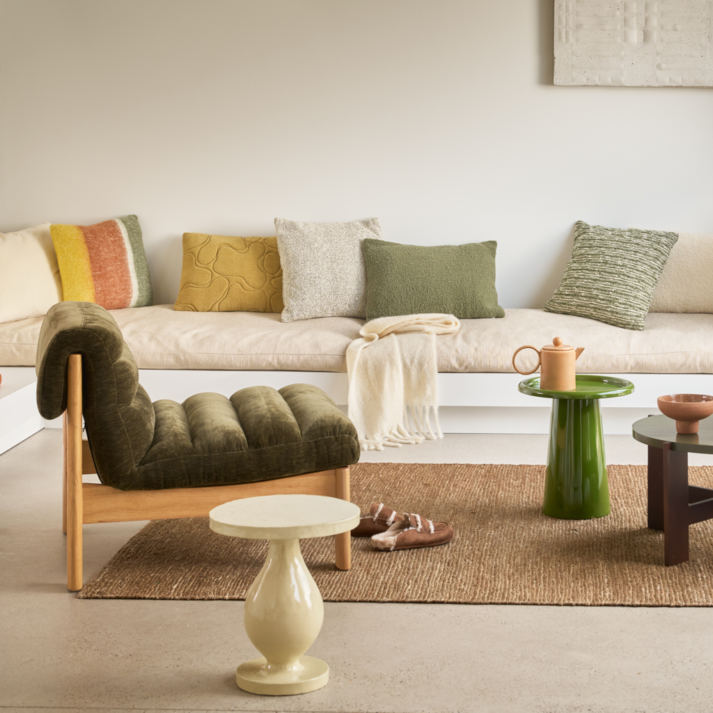 A decorative cushion with woven horizontal stripes in colours mayfly and off-white. Yarn is irregular.