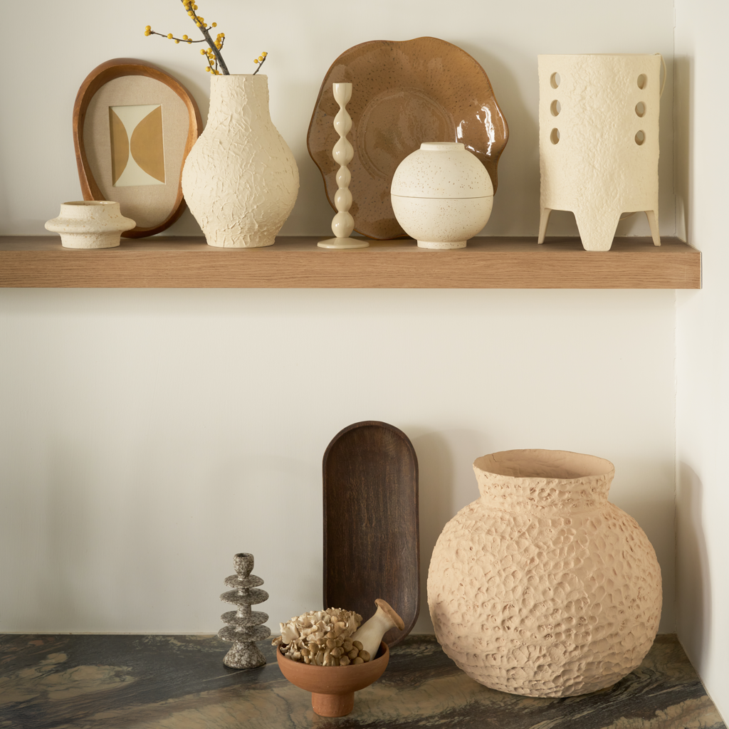 A spherical fragrance holder in off-white with a subtle textured skin, designed to store your whole fragrance bottle with an opening for scented sticks.